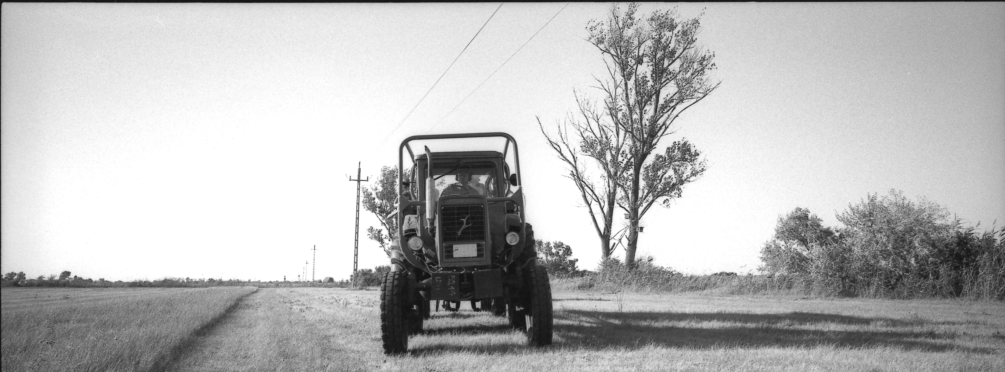 A field vehicle standing beneath a poplar tree in the Jászboldogháza landscape